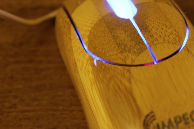 The light of the scroll wheel's LED shines through a small blemish in the mouse.