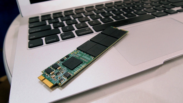 SSD memory module shown on top of MacBook laptop.