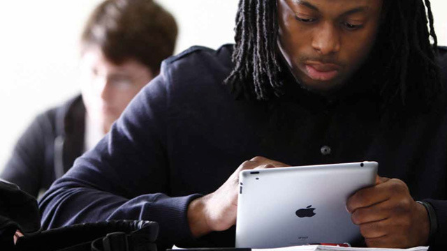 An ACU student uses an iPad in class, part of the school's 