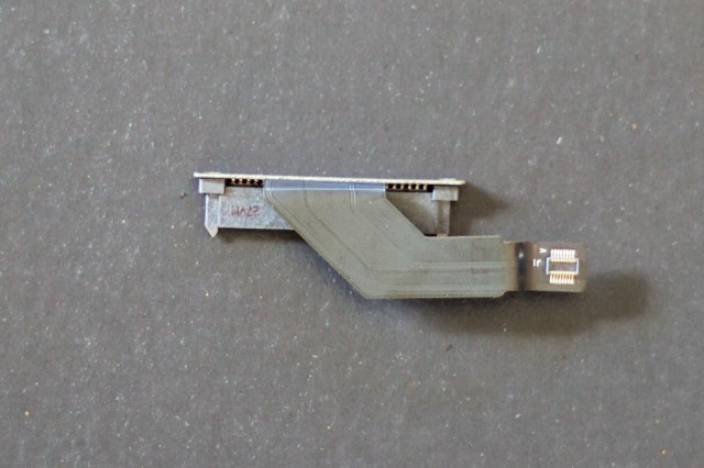 SATA adapter, connecting the SSD's power and data leads to the L-shaped motherboard (or logic board, in Apple parlance).