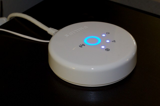 The Hue bridge, with all status lights on. The central ring illuminates the button used for linking the hub to the Hue app or other things.