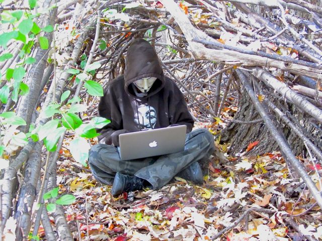 Doyon beneath a primitive shelter he built in Canada.