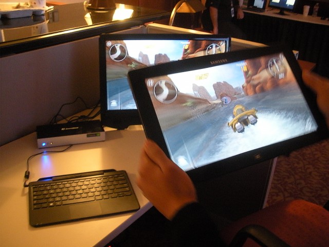 Wilocity's Teresa Liou plays a game on a tablet, which is mirrored onto the monitor through the docking station on the left.