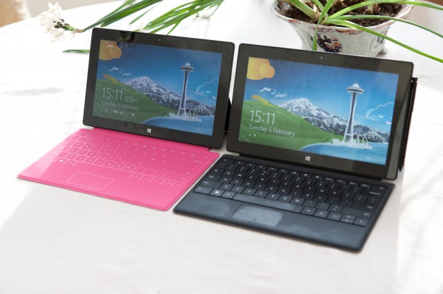 On the left, Surface RT with the magenta Touch Cover. On the right, Surface Pro with the black Type Cover.