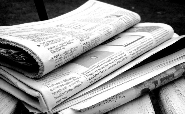 A stack of analog newspapers.