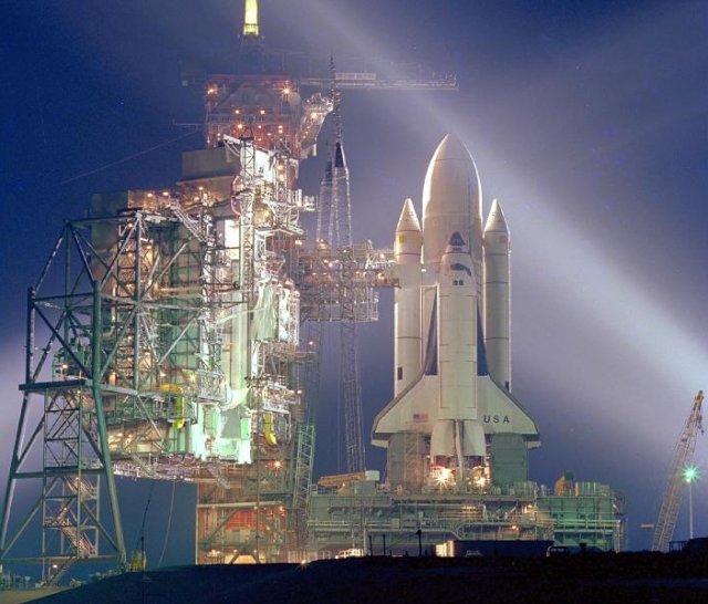 A timed exposure of STS-1, at Launch Pad A, Complex 39, turns the space vehicle and support facilities into a nighttime fantasy of light. Structures to the left of the shuttle are the fixed and the rotating service structure. 