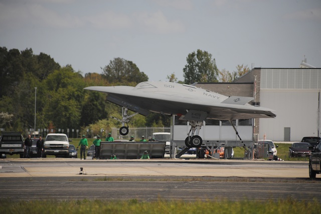 The X-47B, hook down, comes in for its first successful "trap," no Goose or Maverick required.