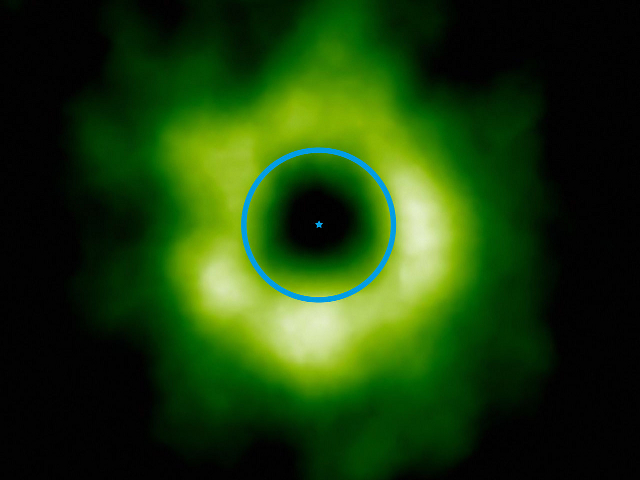 The green is emission from a molecule revealing the location of carbon monoxide ice in a young star system. The blue line is the size of the orbit of Neptune. According to planet-formation models, the region where carbon monoxide freezes is exactly where this observation finds it.