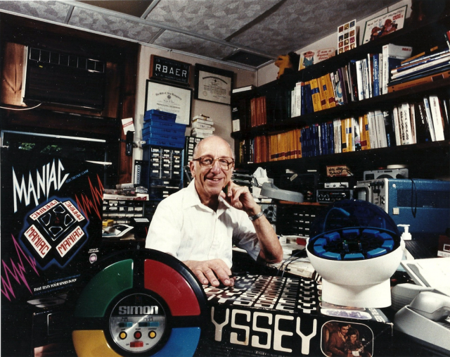 Ralph Baer posing in his personal lab with some of his most famous products.