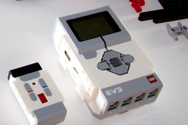 At right, the programmable EV3 "intelligent brick," which houses the microprocessor and which drives the motors and sensors. At left, the small multi-channel infrared remote control.