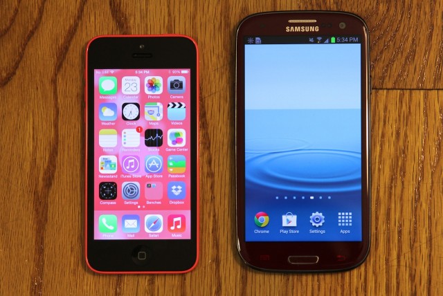 The midrange Galaxy S III (right) and its 4.8-inch screen dwarf the 5C.