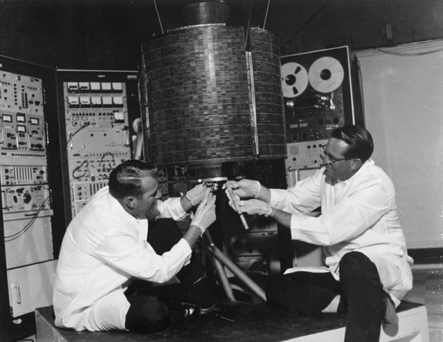 NASA engineers check out "EarlyBird," Intelsat's first geosynchronous commercial communications satellite, before launch in 1965.