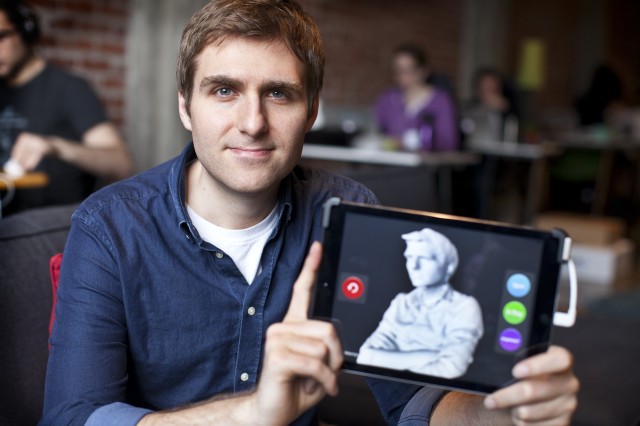 Jeff Powers, CEO of Occipital, sits holding an iPad with a 3D image of himself that was scanned earlier.