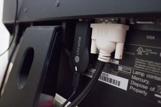 A Chromecast dongle, nestled safely into the back of an HDMI-equipped computer monitor.