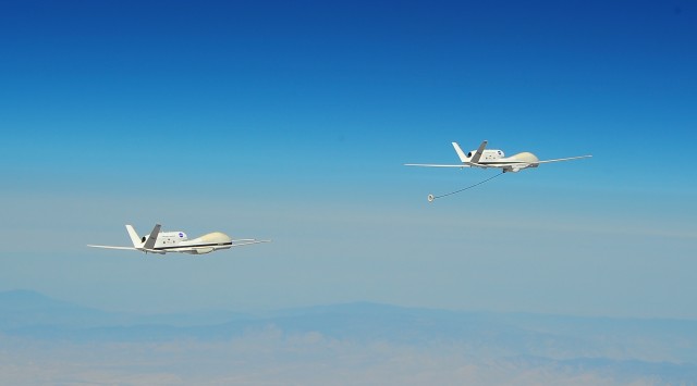 Two NASA Global Hawk drones in an automated aerial refueling test by Darpa last year. Darpa wants software that helps drones work together as a team with minimal human guidance.