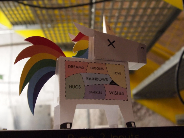 La carcasa del laboratorio LUX tiene muchos pequeños unicornios de papel colocados en la parte superior de los racks de servidores y otros equipos.