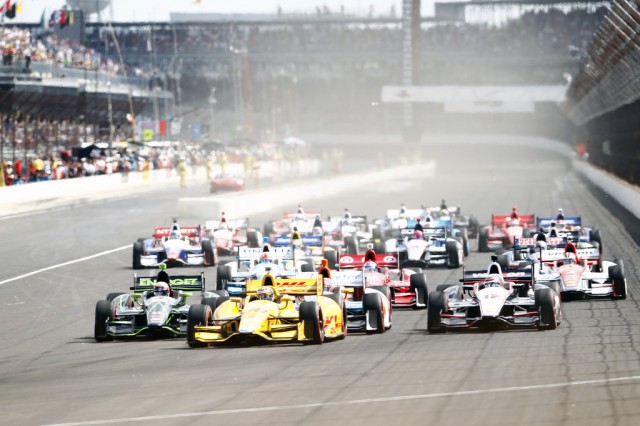 A field of DW12 IndyCars head for turn 1 at the start of the 2014 Grand Prix of Indianapolis, the first time IndyCars have run on the road course at the hundred-year-old track.