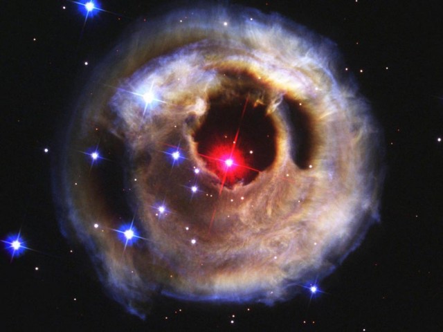A red supergiant star lights up a cloud of dust.  Without detailed spectral information, it's impossible to tell whether these stars have swallowed one of their companions.