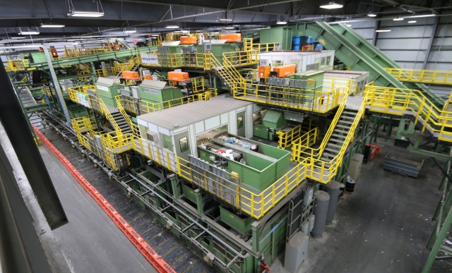 A wide-angle view of the entire New York Sunset Park recycling facility. Lots of individual machinery is tightly clustered around this three-dimensional system of conveyors.