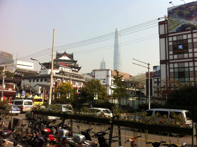 Modern scooters, older buildings, and modern towers all make up Shanghai's current incarnation.