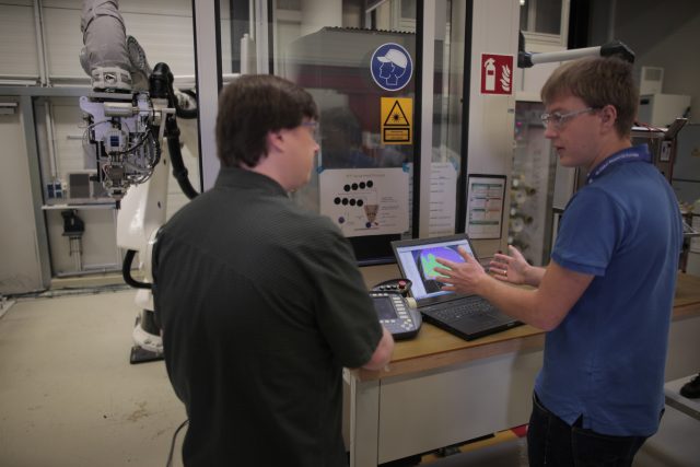 GE's Mathias Messmer (right) in front of the automated fiber placement robot.