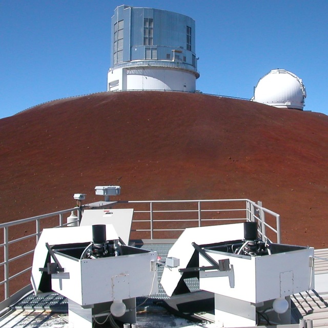These tiny HATNet telescopes (foreground) can detect exoplanets more easily than their big brethren.