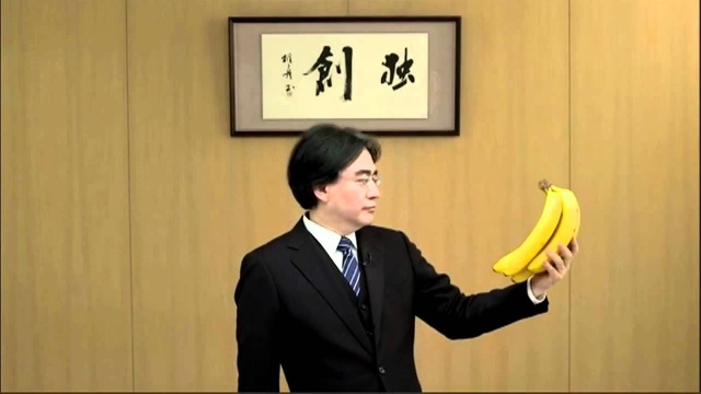 Iwata stares as some bananas during a Nintendo Direct presentation.