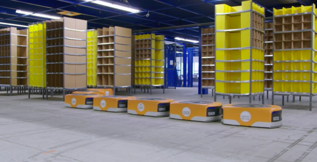 Short, squat robots drive around Amazon's fulfillment centers and pick up stacks that normally are full of products. Then, the robots take requested stacks to warehouse employees for packing purposes (in this photo, the stacks are empty).