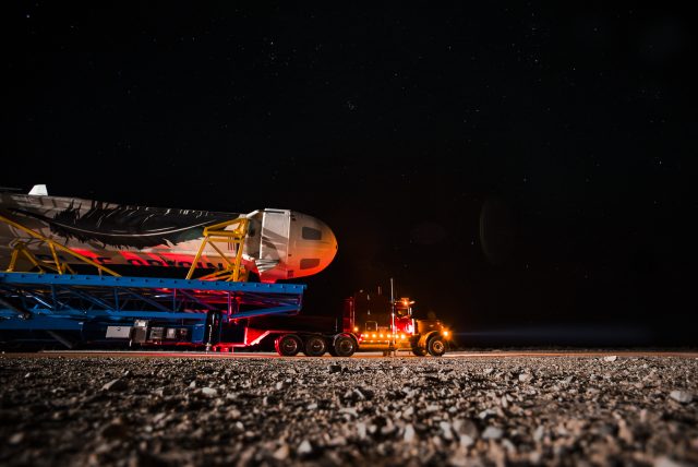 The reused New Shepard booster rolls out to the launch pad at the company's West Texas launch site.