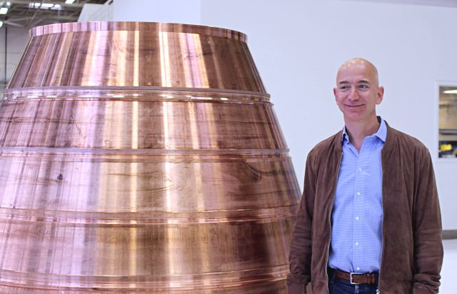 Jeff Bezos stands next to a nozzle of a BE-4 engine in his Blue Origin rocket factory.