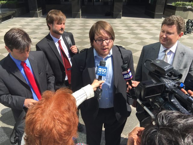 Matthew Keys talks to reporters after he was sentenced in April 2016 to two years in prison, surrounded by his lawyers, including Mark Jaffe (far left).