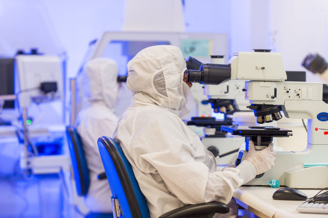 An engineer examines a gallium nitride integrated circuit under a microscope in a fabrication facility at Raytheon's Integrated Air Defense Center in Andover, Massachusetts. 