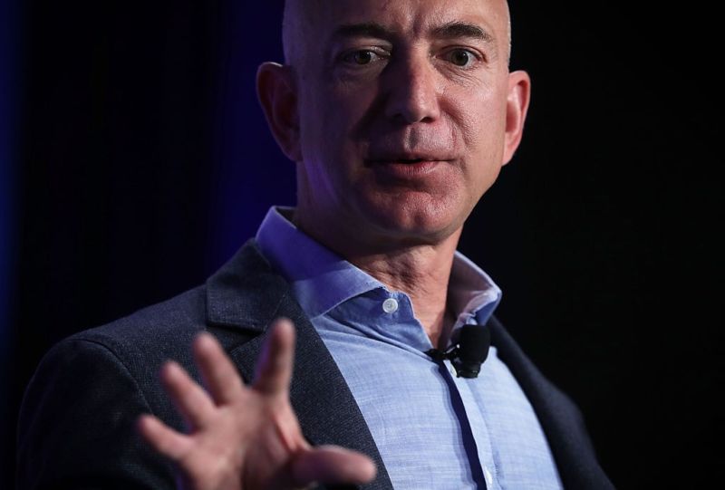 A man in a suit gestures during a presentation.