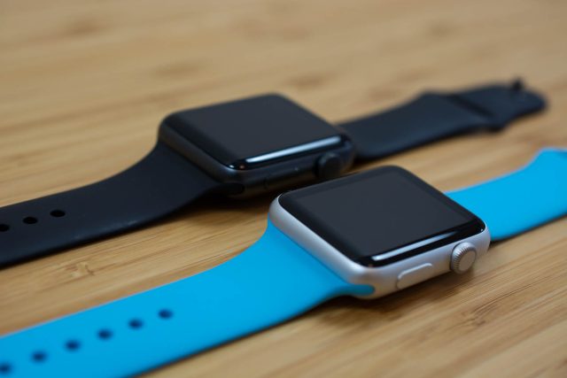 Series 2 (black band) next to Apple Watch Series 1 (blue band).