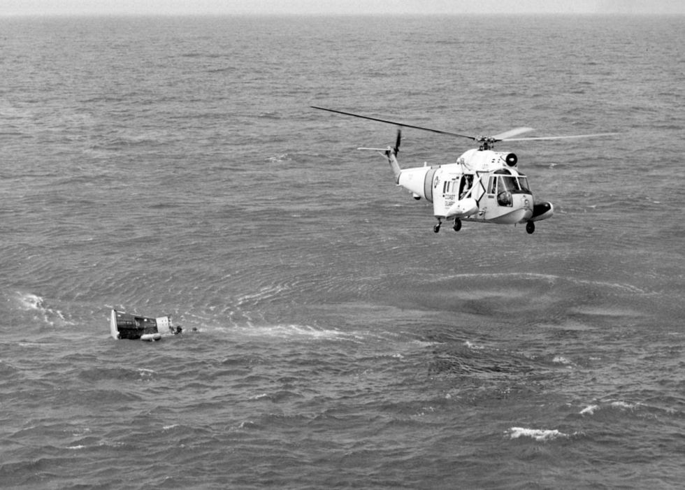 A US Coast Guard Sikorsky Seaguard helicopter flies over the Gemini 3 space capsule flown by astronauts Gus Grissom and John Young after it splashed down in the Atlantic Ocean in 1965.