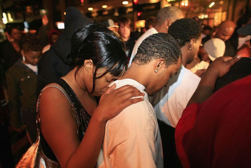 MILWAUKEE, WI: A woman rests her head on the shoulders of a man as a group of supporters stop and pray after a verdict of not guilty came back on four of the five charges for the three former police officers who stood trial for the beating of Frank Jude Jr.