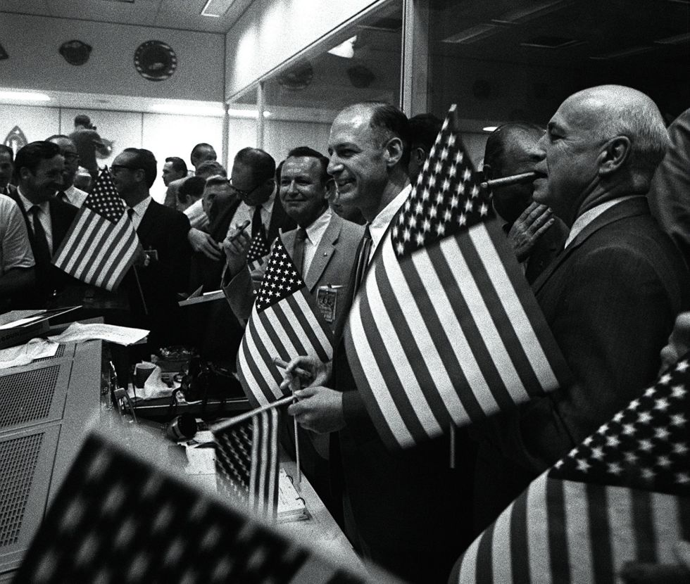 Key officials celebrate the successful conclusion of the Apollo 11 lunar landing mission. Robert R Gilruth is at the far right, George Low, Manager, Apollo Spacecraft Program, is next to him and Chris Kraft Director of Flight Operations is in the center.