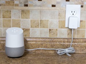 Voicebot plugged in on tiled surface.
