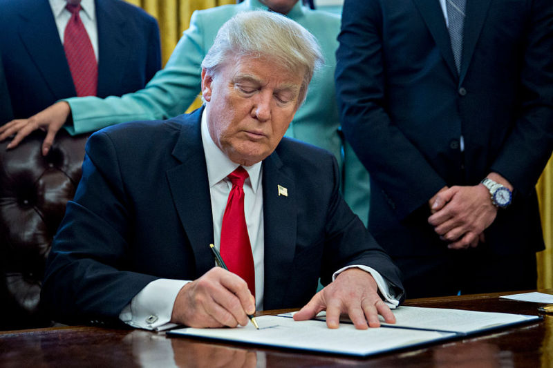 US President Donald Trump signs an executive order in the Oval Office of the White House on January 30. He may soon be signing one related to H-1B visas.