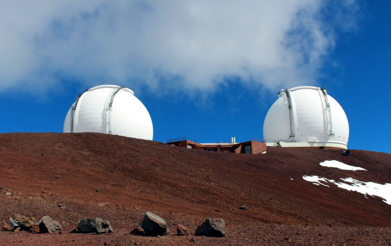 Two large white domes on a reddish landscape.