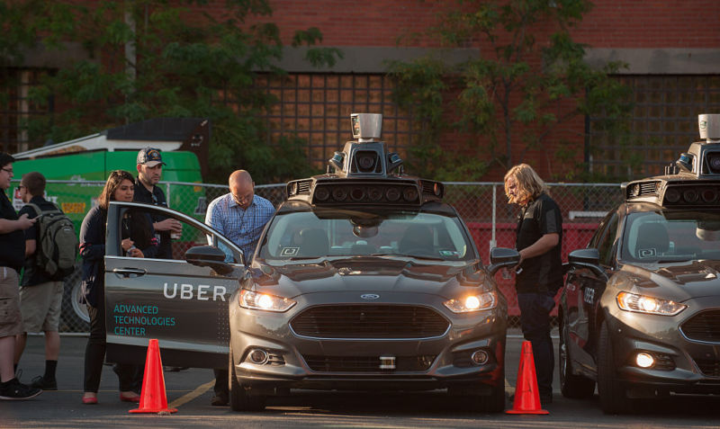 Employees inspect an Uber self-driving car in Pittsburgh last year. 