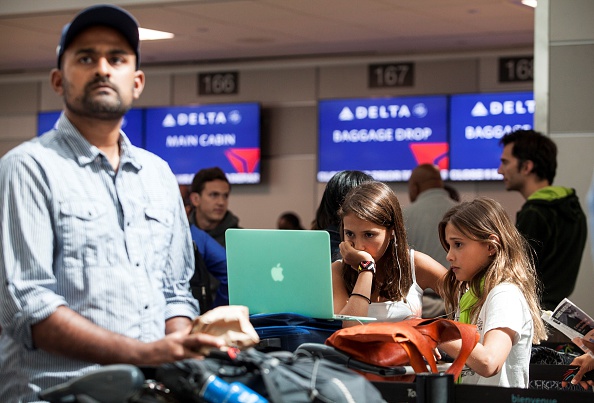 Kids watch a laptop screen at Pearson International airport, in Toronto, Canada.