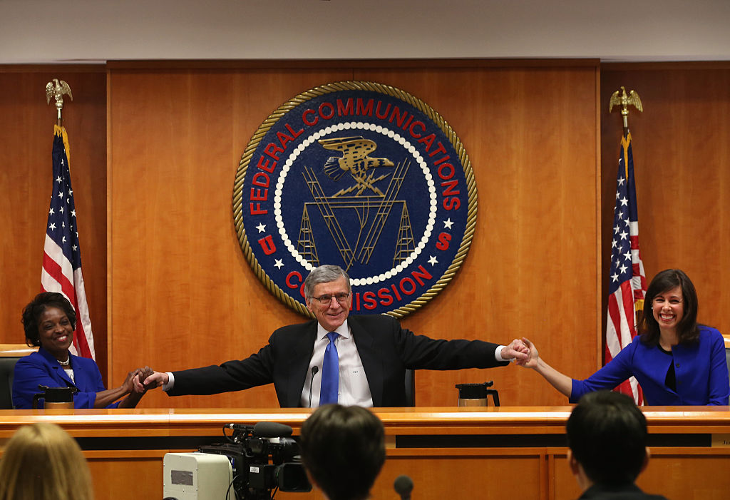 Then-FCC Chairman Tom Wheeler celebrates with fellow Democratic commissioners Mignon Clyburn (L) and Jessica Rosenworcel (R) after the February 2015 net neutrality vote. 