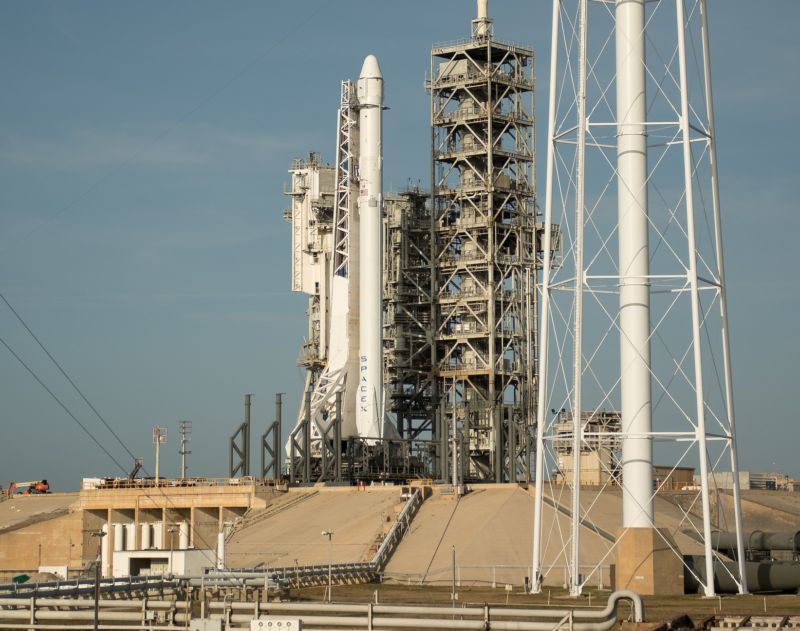 The SpaceX Falcon 9 rocket, with the Dragon spacecraft onboard, is seen shortly after being raised vertical at Launch Complex 39A.