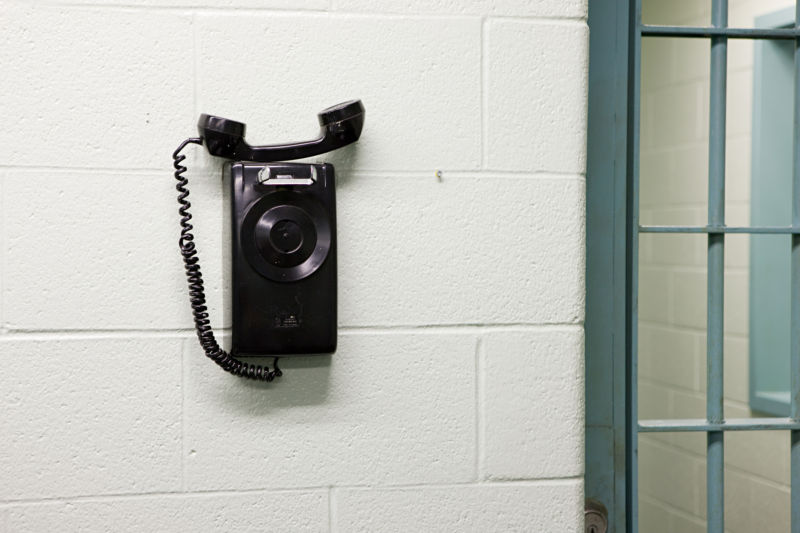 A telephone on a wall inside a prison.