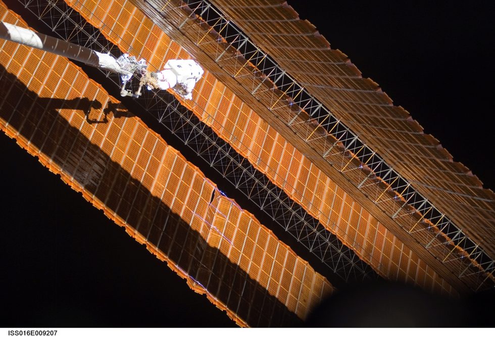 While anchored to a foot restraint on the end of the Orbiter Boom Sensor System, Parazynski assesses his improvised fix to the solar array.