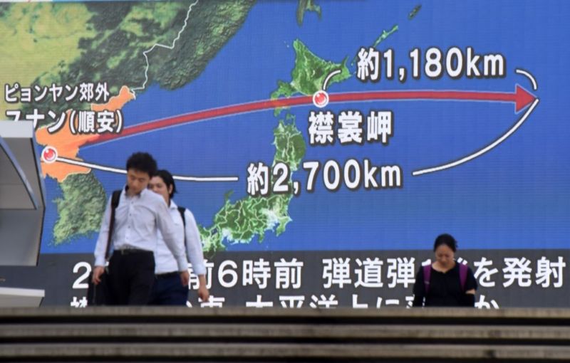  Pedestrians walk in front of a huge screen displaying a map of Japan (R) and the Korean Peninsula, in Tokyo on August 29, 2017, following a North Korean missile test that passed over Japan. 