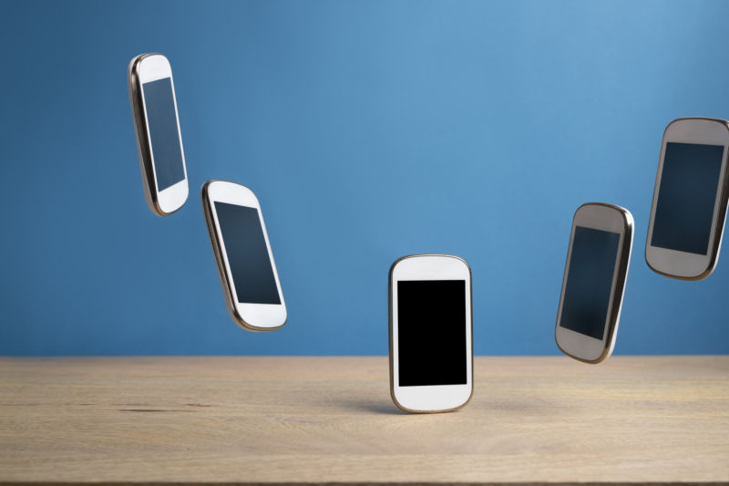 An illustration of several smartphones hovering above a table.