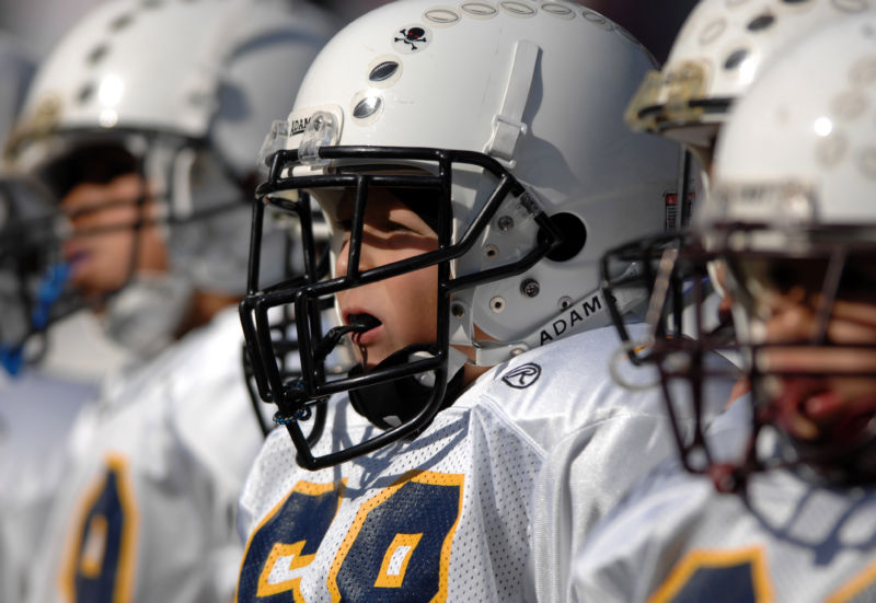 Youth Pee-Wee football players wait to take the field. 
