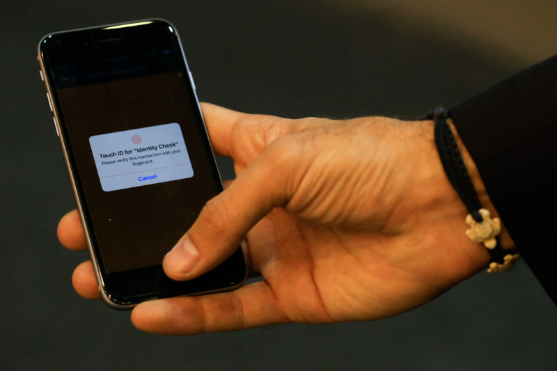 An employee demonstrates fingerprint security software on a smartphone at the MasterCard Inc. stand at the Mobile World Congress in this arranged photograph in Barcelona, Spain, on Wednesday, February 24, 2016.